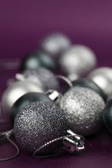 Silver Christmas ornaments on purple background. Copy space