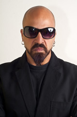 Fototapeta premium man with glasses blacks, black coat and beard, bouncer bodyguard