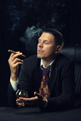 The man with a cigar and a glass of cognac