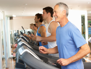 Fototapeta na wymiar Senior Man On Running Machine In Gym