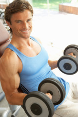 Fototapeta na wymiar Man Working With Weights In Gym