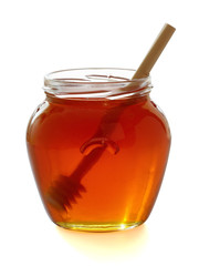 Wooden dipper with jar of honey.