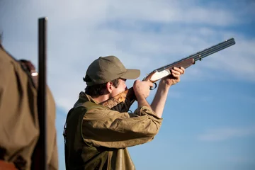 Poster Hunter aiming at the hunt during a hunting party © NanoStock
