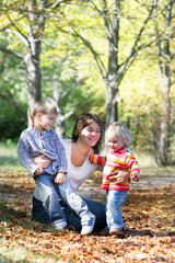 Fototapeta na wymiar mother with two kids in autumn park