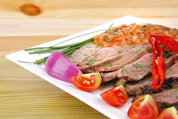 beef on plate with peppers on wood