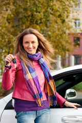 The happy woman showing the key of her new car