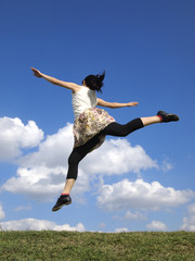 青空にジャンプする女性