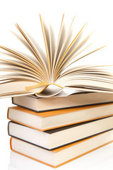 stack of books with open book over white background