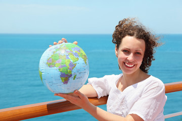 woman on deck of ship among sea with globe