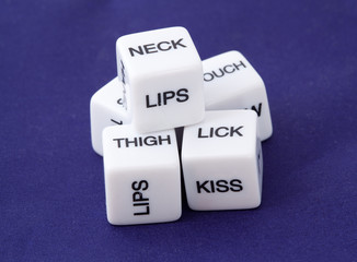 White dice with erotic messages on the sides on blue © Pavel Losevsky