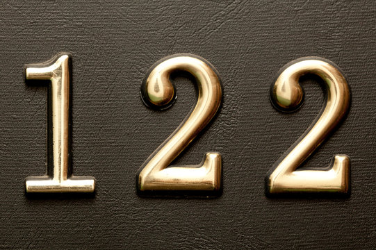 Brass door number 122 on the dark leather background.
