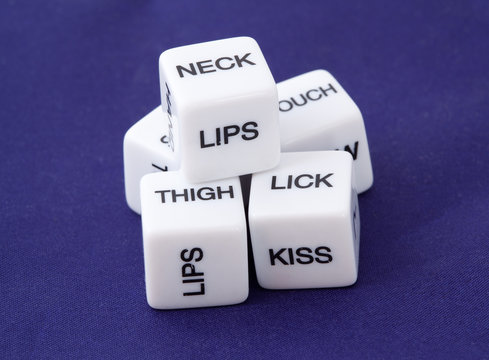 White dice with erotic messages on the sides on blue