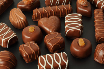 many chocolate appetizing candys with icing on dark