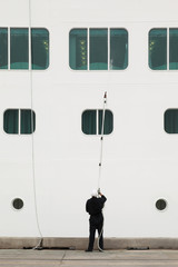 seaman standing in dock and cleaning window of ship