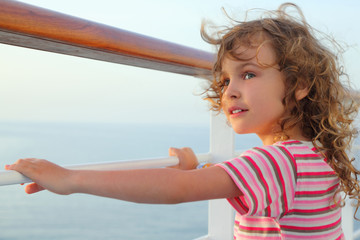 little curl girl standing on cruise liner deck, hands on rail, h