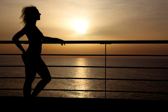 silhouette of curl girl standing on cruise liner deck