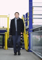 Mann im Anzug mit Tasche läuft entgegen