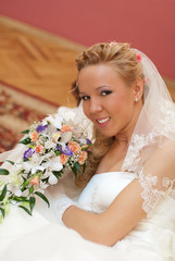 Naklejka premium Wedding. Portrait of bride with bouquet in hands indoors.