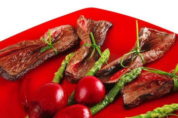 meat slices and asparagus on red