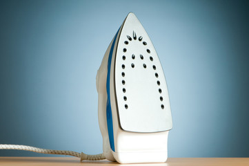 Modern electric iron against the colorful background