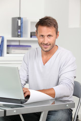 Closeup of employee in the office working on laptop computer