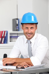 Site manager in the office with blue helmet