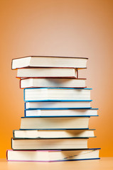 Stack of text books against gradient background