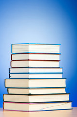Stack of text books against gradient background