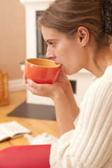 Junge Frau vor Kamin