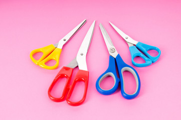 Colorful scissors on the color paper background