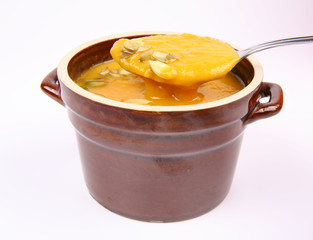Bowl of Pumpkin soup being eaten with a spoon