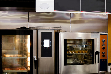 close-up of a professional oven with baguettes cooking in it in