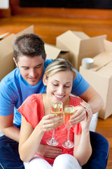 young couple celebrating their removal with champagne