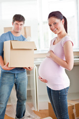 Fototapeta na wymiar adorable pregnant woman with husband holding cardboard in the ki