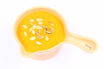 Bowl of pumpkin soup on white background