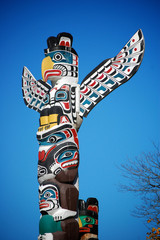 A colorful totem pole in Stanley Park, Vancouver. - obrazy, fototapety, plakaty