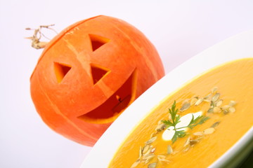 Pumpkin soup with cream, seeds, parsley and Jack-o'-lantern