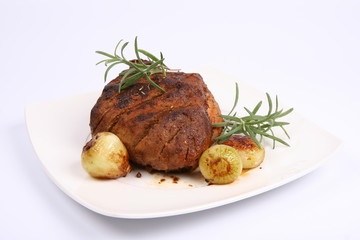 Roast pork with some onions and rosemary on a plate