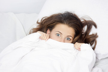 young scared woman in bed