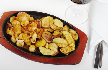 Seafood and fried potatoes with wine and cutlery