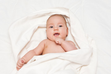 Adorable smiling little girl wrapped in blanket