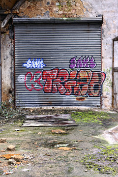 Rolling door covered with graffiti in an abandoned warehouse