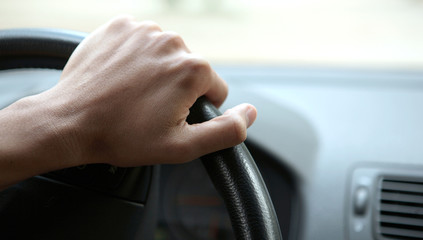 Close-up of a male hand on steering wheel in a modern car in the