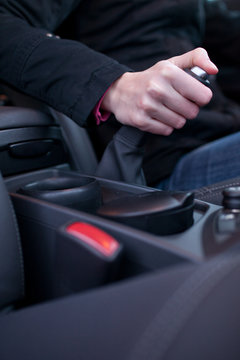 driving concept - young female driver using handbrake