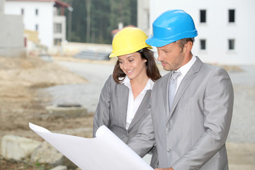 Team of architects checking plans on site