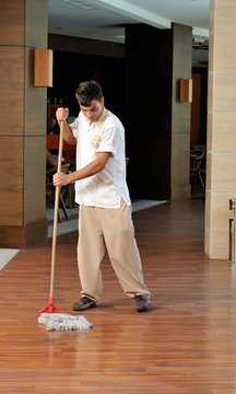 Young housekeeper mobbing the floor - a series of HOTEL images.