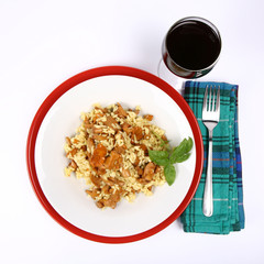 Risotto with mushrooms ,glass of wine and a fork on a napkin