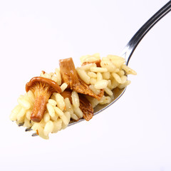 Risotto with mushrooms on a fork on white background
