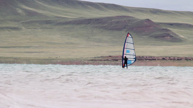 Windsurfer sailing fast in the big waves.