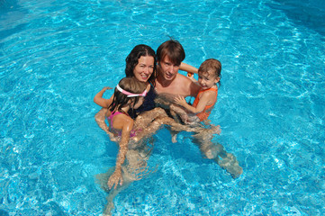 Family with two kids in swimming pool